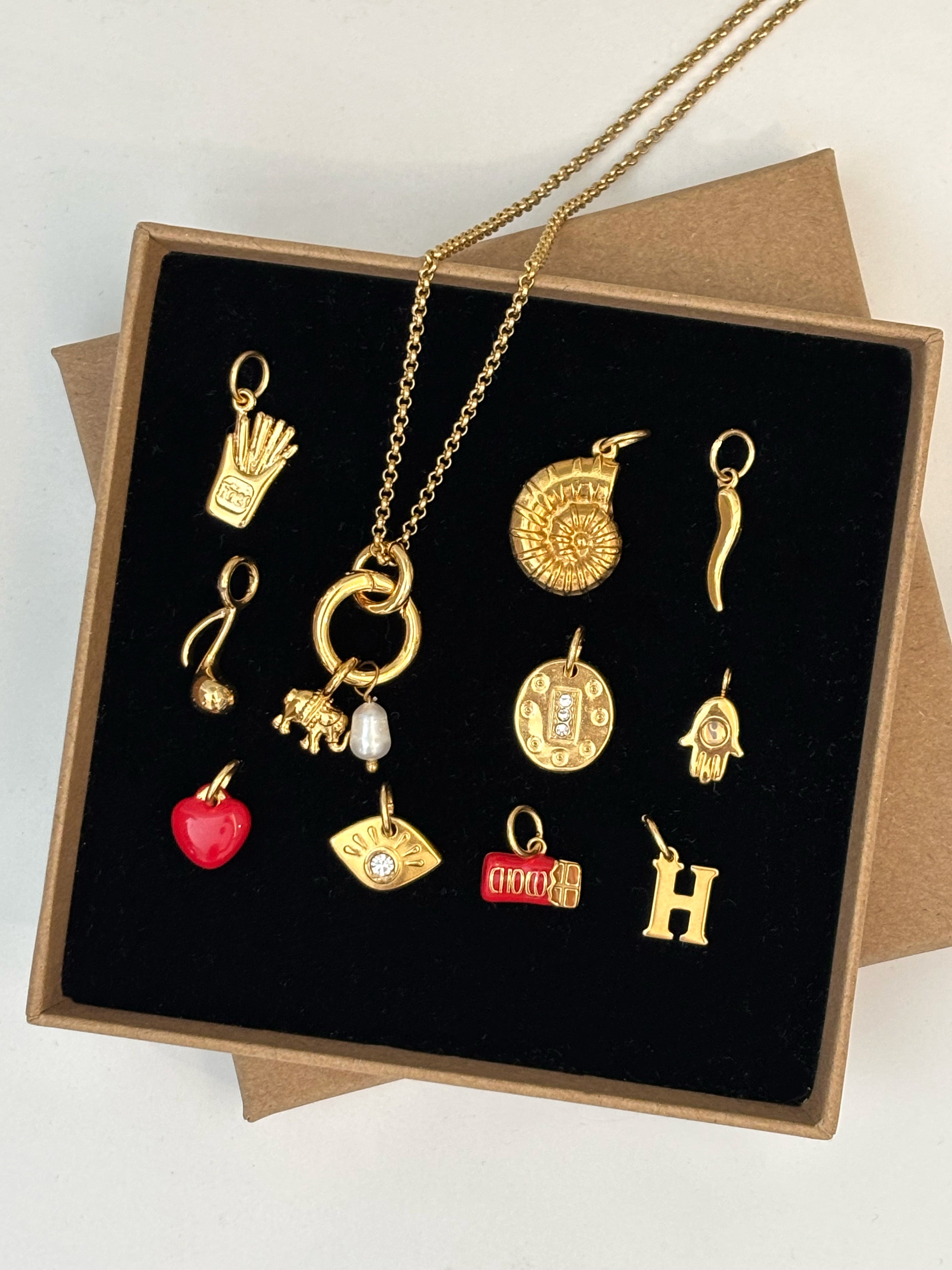 Collection of gold necklaces with various charms in a box